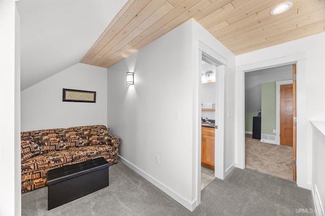 living area featuring light colored carpet, visible vents, vaulted ceiling, wood ceiling, and baseboards