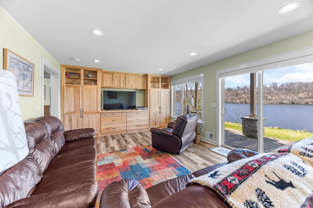 living room featuring visible vents, light wood-style flooring, and recessed lighting
