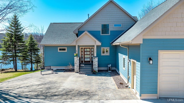 view of front of property featuring roof with shingles and a garage