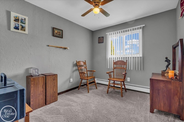 living area featuring a baseboard heating unit, carpet flooring, a ceiling fan, and baseboards