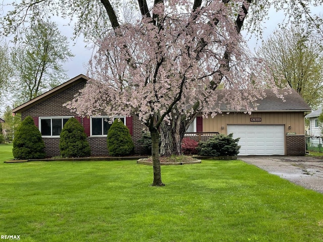 view of front of home featuring brick siding, driveway, a garage, a front yard, and board and batten siding