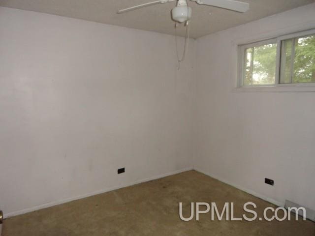 carpeted empty room with baseboards and ceiling fan