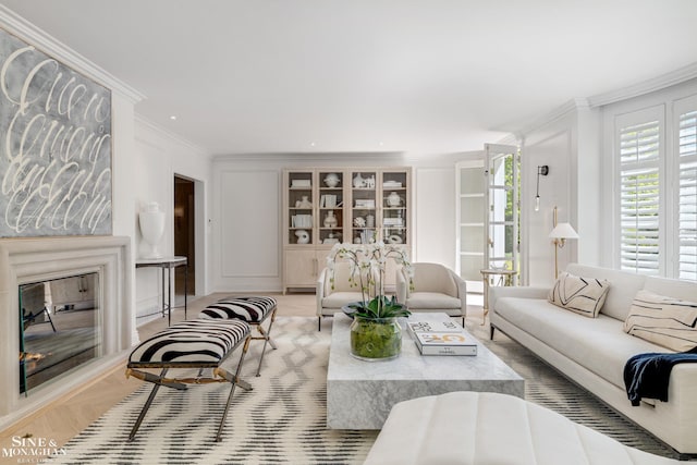 living room with crown molding and a glass covered fireplace