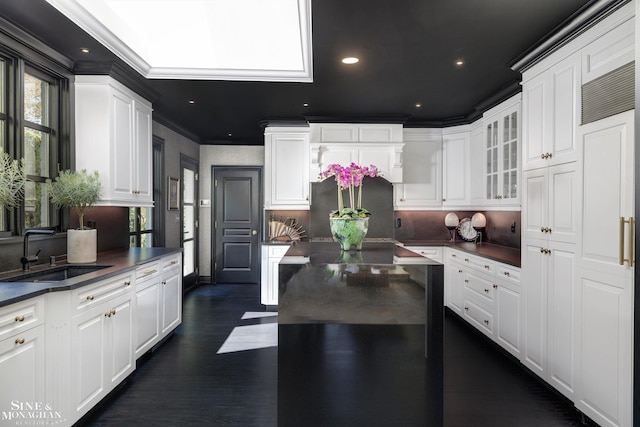 kitchen featuring dark countertops, plenty of natural light, refrigerator, and a sink