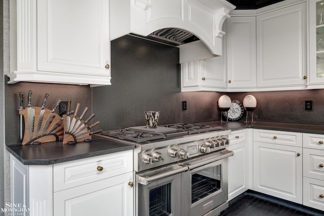 kitchen featuring white cabinetry, backsplash, range with two ovens, and dark countertops