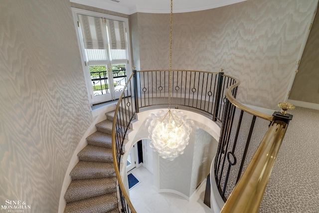 stairway with baseboards, a chandelier, wallpapered walls, and carpet floors