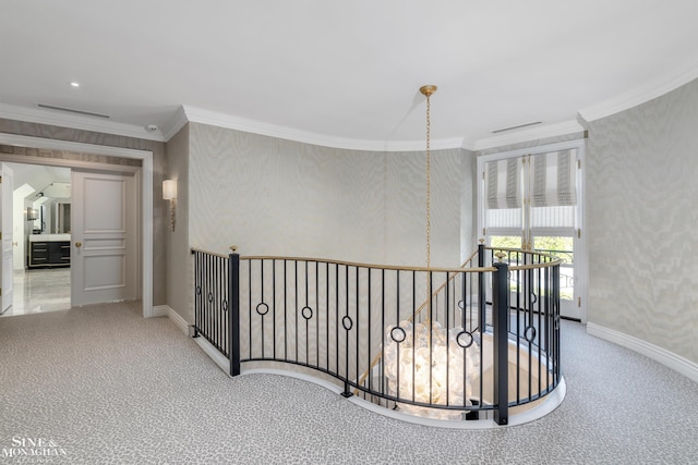 corridor with an upstairs landing, baseboards, ornamental molding, and carpet floors