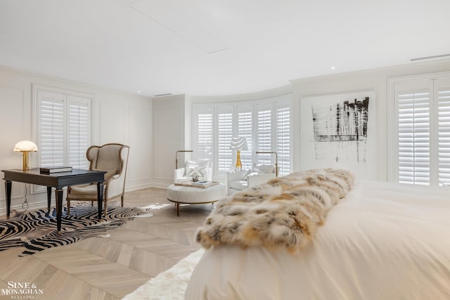 bedroom featuring crown molding and a decorative wall