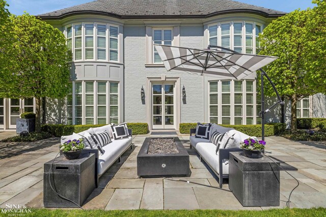 view of patio with an outdoor living space with a fire pit and french doors