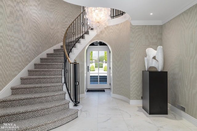 stairs featuring an inviting chandelier, wallpapered walls, baseboards, marble finish floor, and ornamental molding