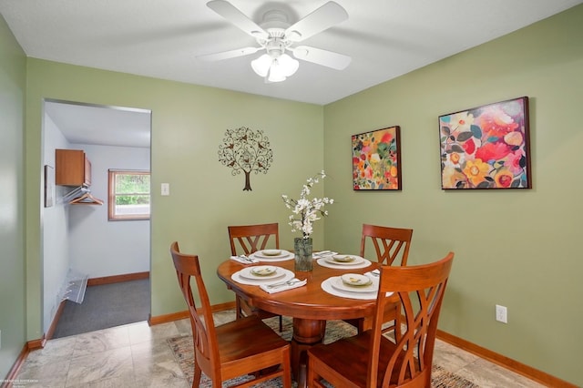 dining space with baseboards and ceiling fan