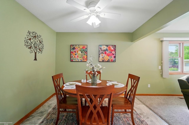 carpeted dining area with baseboards and a ceiling fan