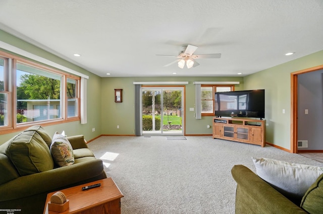 living room with light colored carpet, baseboards, a ceiling fan, and visible vents