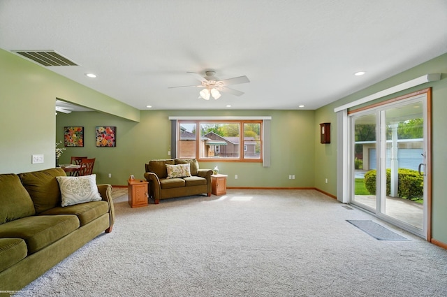 carpeted living area featuring baseboards, a wealth of natural light, ceiling fan, and visible vents