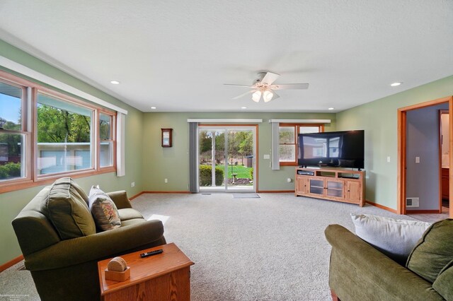 living area featuring light colored carpet, visible vents, recessed lighting, a ceiling fan, and baseboards