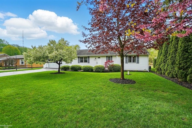 view of front facade with concrete driveway, a front lawn, and an attached garage