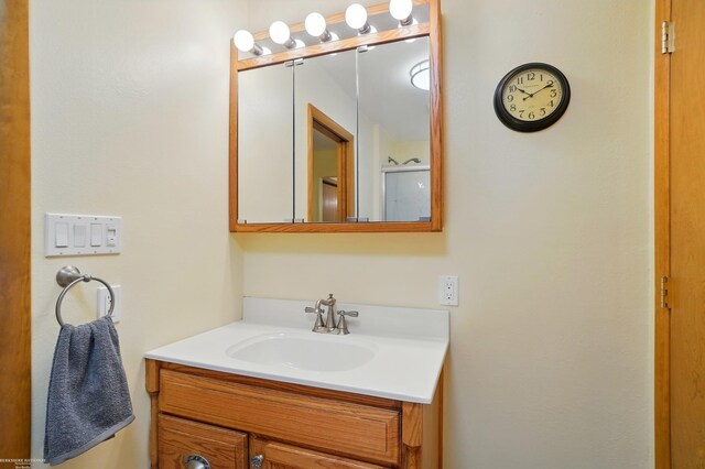 bathroom with walk in shower and vanity