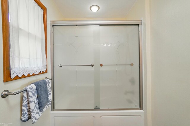 bathroom featuring a shower with door