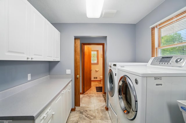 laundry area featuring washing machine and clothes dryer, cabinet space, baseboards, and marble finish floor
