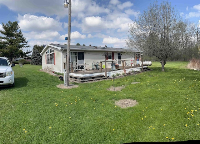 rear view of property featuring a yard and a wooden deck
