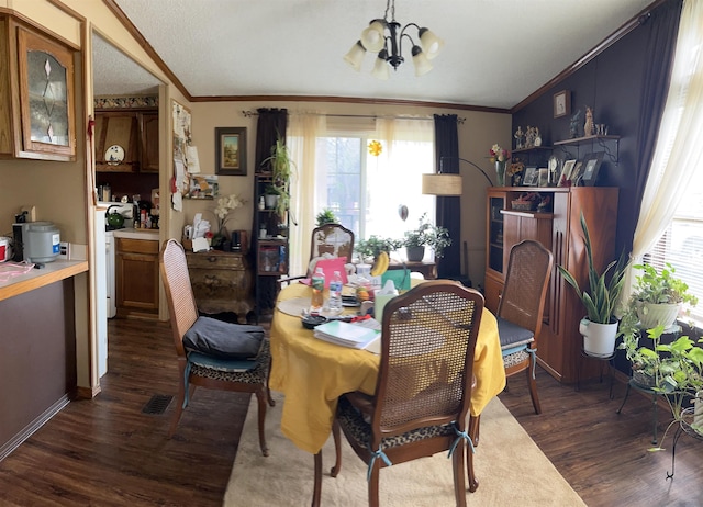 dining room with crown molding, a notable chandelier, dark wood-style floors, and a healthy amount of sunlight