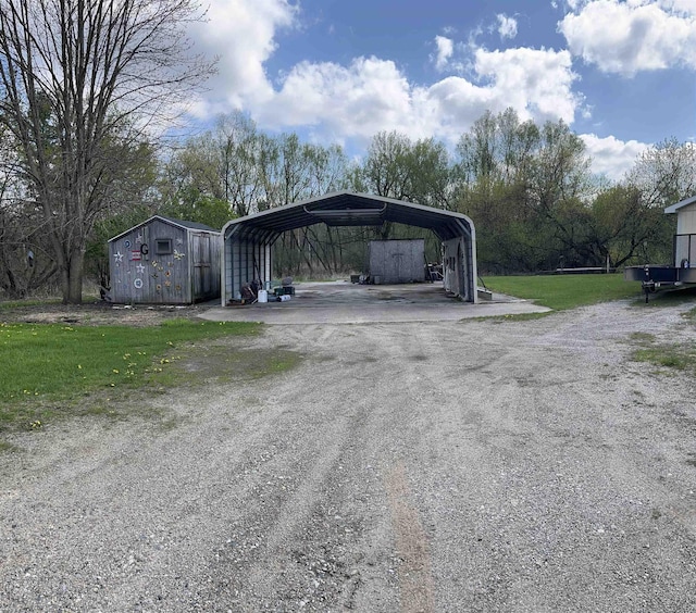 view of parking / parking lot with a storage shed, dirt driveway, and a carport