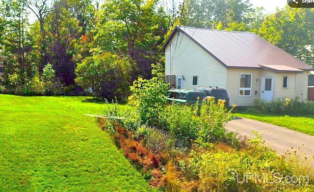 view of side of property with a yard and metal roof