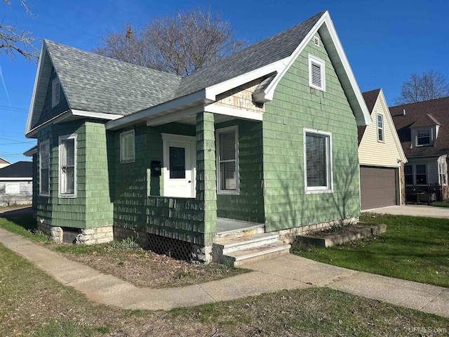 view of front of home featuring roof with shingles and concrete driveway