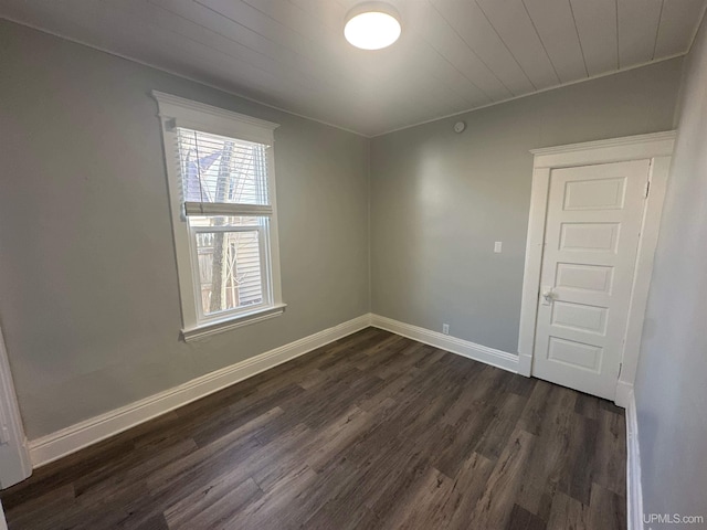 unfurnished room with wood ceiling, baseboards, and dark wood-style floors