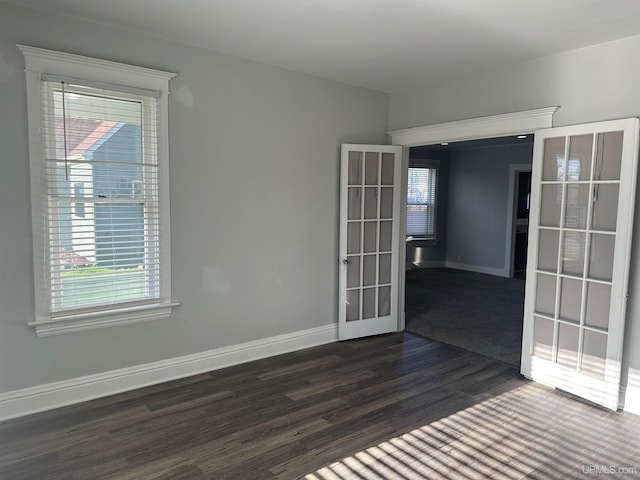 unfurnished room with baseboards, dark wood-style flooring, french doors, and plenty of natural light