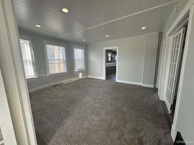 interior space featuring visible vents, baseboards, dark carpet, and recessed lighting