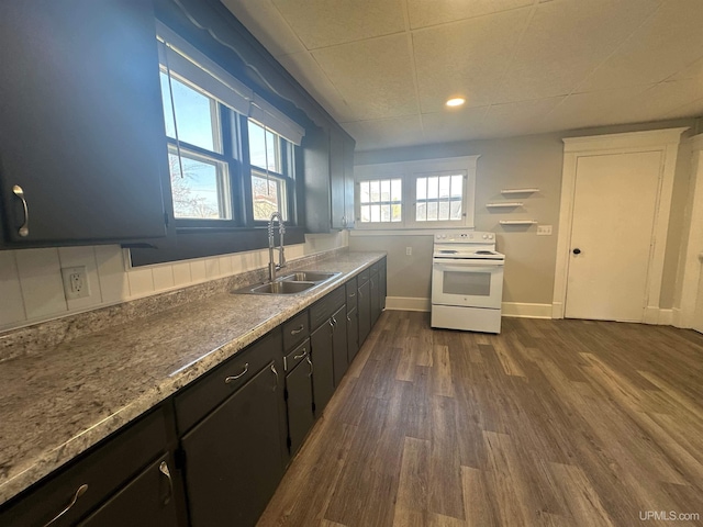 kitchen featuring recessed lighting, baseboards, dark wood finished floors, a sink, and white range with electric cooktop