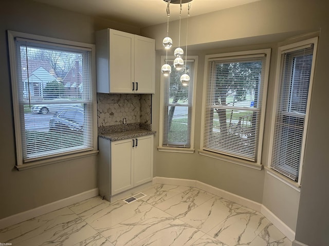 11968 Lakepointe St, Detroit, MI 48224 - unfurnished dining area featuring marble finish floor, visible vents, baseboards, and a healthy amount of sunlight