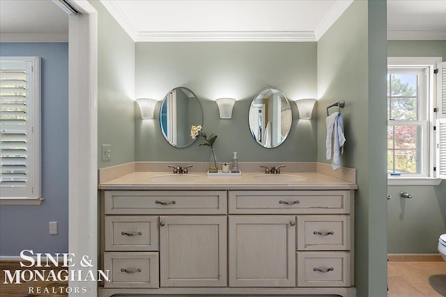 full bath with ornamental molding, toilet, double vanity, and baseboards