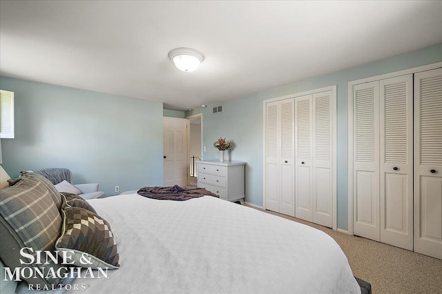 bedroom featuring two closets and carpet flooring