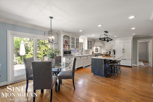 dining space with a chandelier, ornamental molding, dark wood-style flooring, recessed lighting, and baseboards