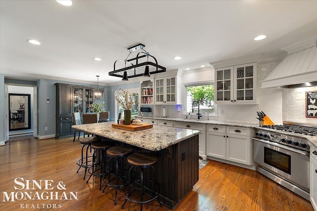kitchen with appliances with stainless steel finishes, a kitchen island, a kitchen breakfast bar, white cabinets, and backsplash