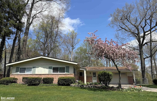 ranch-style home featuring brick siding, an attached garage, a front lawn, and driveway