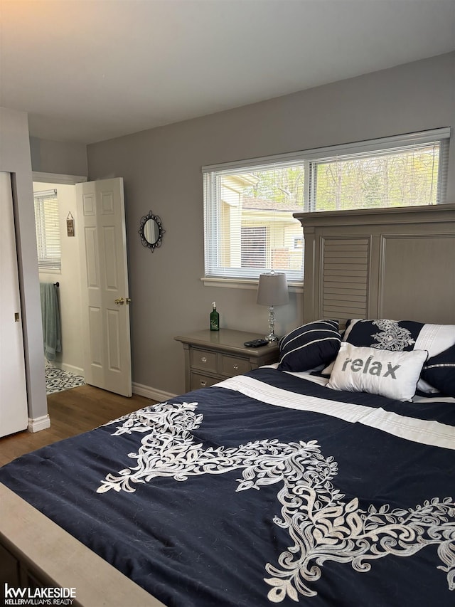 bedroom featuring wood finished floors and baseboards
