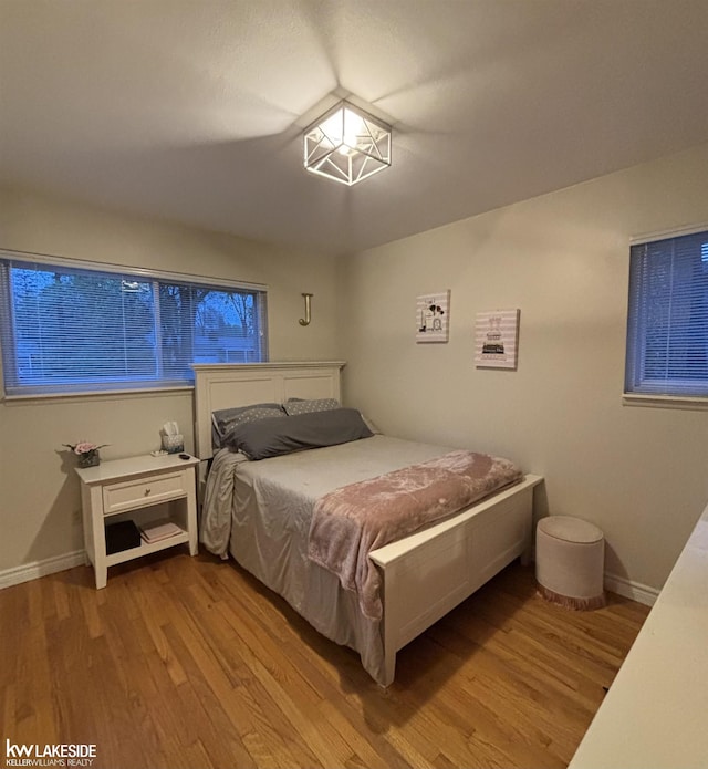 bedroom featuring wood finished floors and baseboards