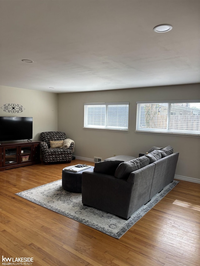 living area with wood finished floors, baseboards, and recessed lighting