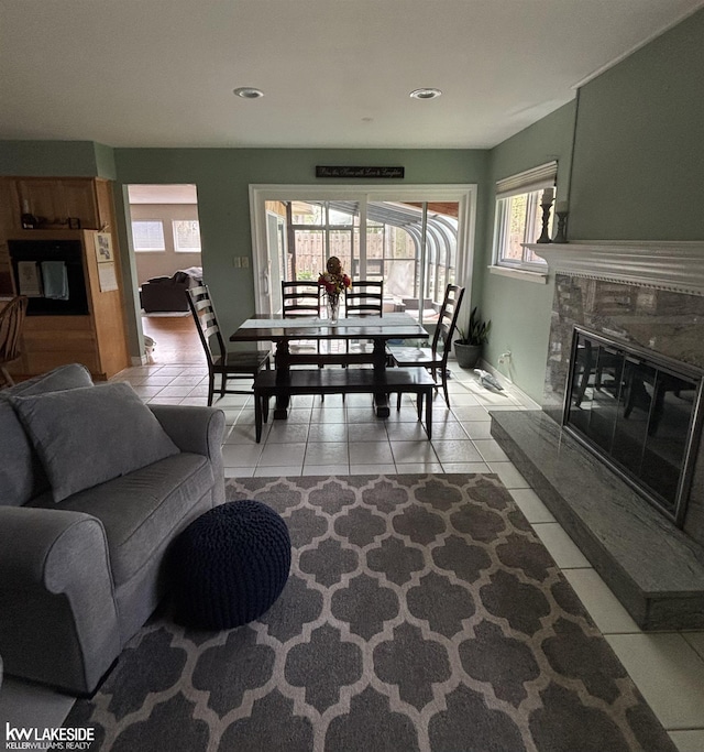living room with light tile patterned flooring, plenty of natural light, a premium fireplace, recessed lighting, and baseboards