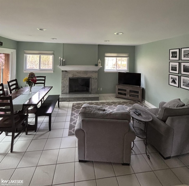 living room with light tile patterned floors, recessed lighting, a premium fireplace, and baseboards