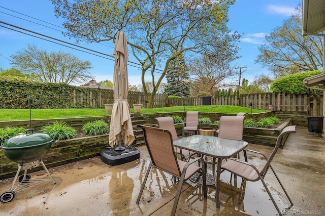 view of patio featuring outdoor dining space, a grill, and a fenced backyard