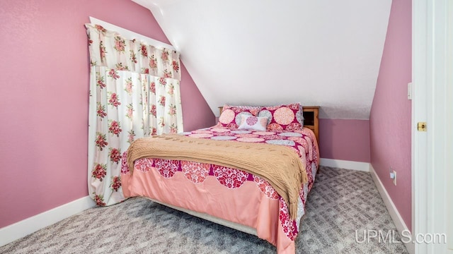 carpeted bedroom featuring lofted ceiling and baseboards