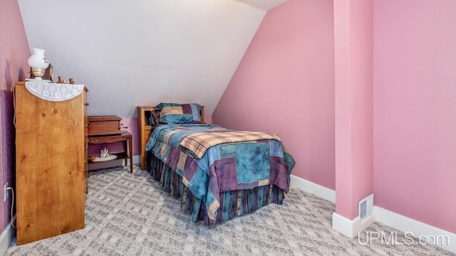 bedroom with vaulted ceiling, carpet floors, and baseboards