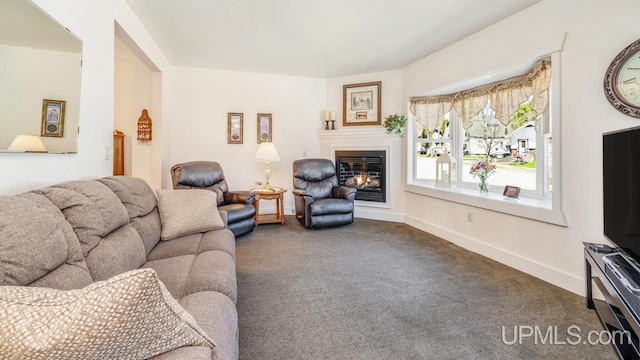 living area featuring carpet floors, a glass covered fireplace, and baseboards