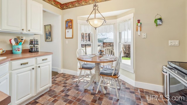 dining area with baseboards and stone finish floors