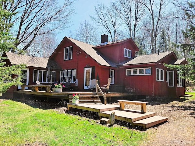 N15505 Black River Rd, Ironwood, MI 49938 - rear view of property featuring a chimney, a wooden deck, a lawn, and a shingled roof