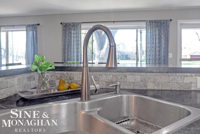 kitchen view of a sink and dark countertops